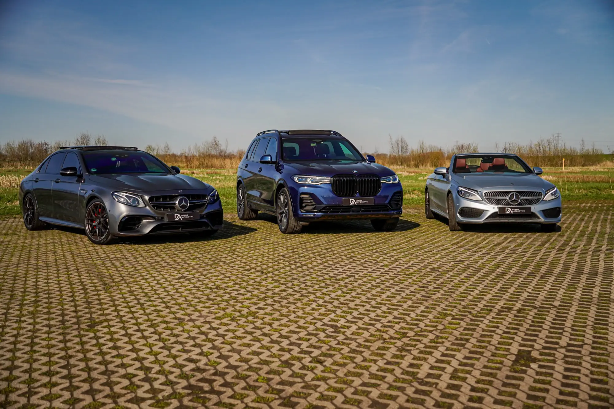 Drie auto's van Dennis Automotive naast elkaar